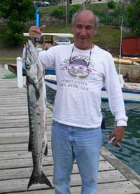 angler holds up a barracuda