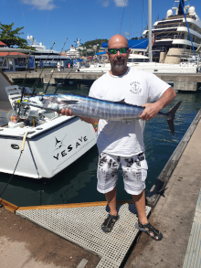 Sandals client holds a wahoo he caught back at the dock